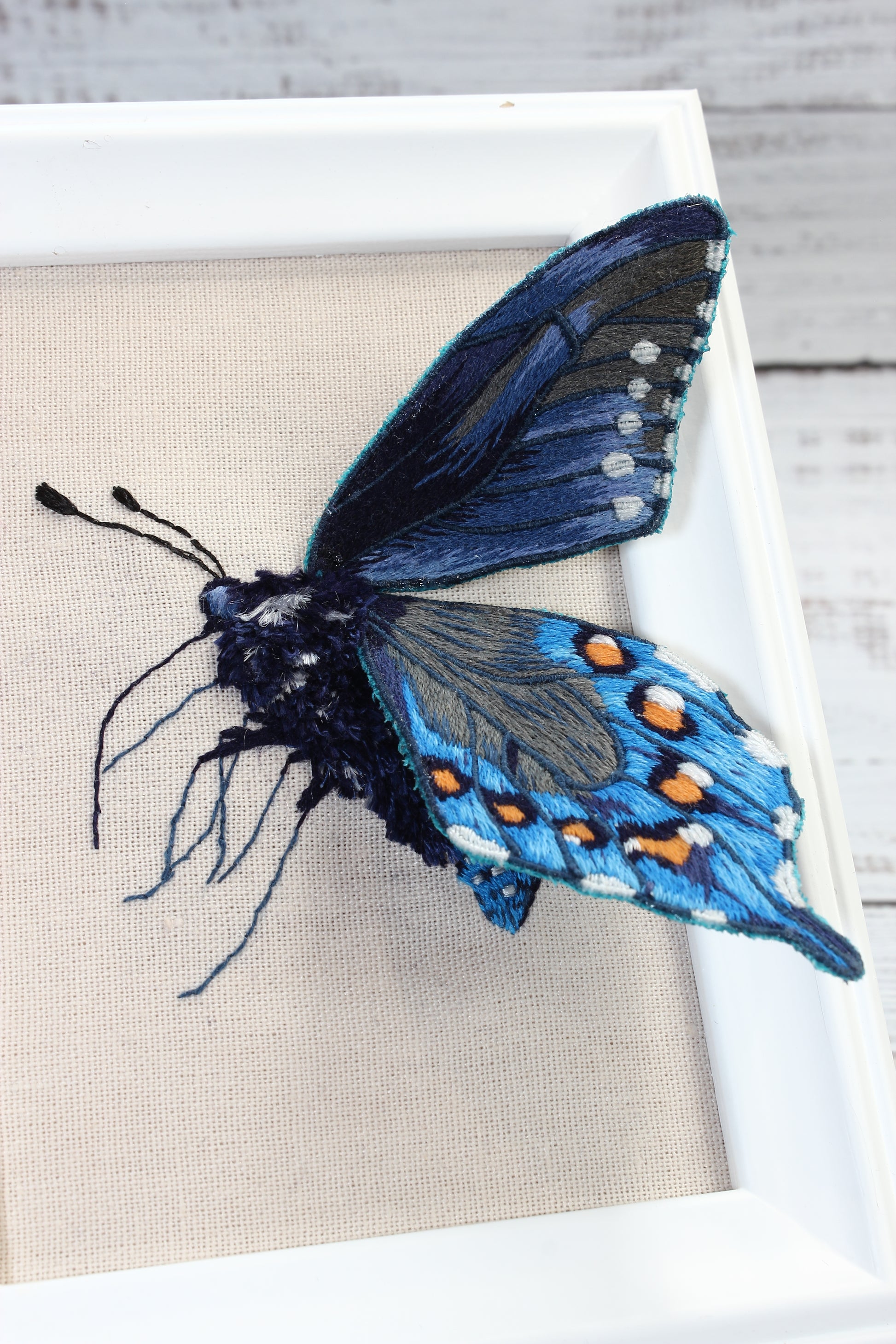 Embroidered butterfly on a beige fabric background